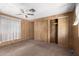 Spacious bedroom with ceiling fan, wood-paneled walls, and large closet at 11411 N 91 Ave # 56, Peoria, AZ 85345