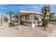 Tan mobile home with carport, steps, and palm trees at 11411 N 91 Ave # 56, Peoria, AZ 85345