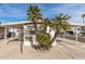 Tan mobile home with carport, palm trees, and paved driveway at 11411 N 91 Ave # 56, Peoria, AZ 85345