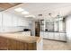 View of a kitchen with wood paneling, white cabinets and a gas stove at 11411 N 91 Ave # 56, Peoria, AZ 85345
