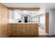 A galley kitchen with wood paneling, white cabinets, and a gas stove at 11411 N 91 Ave # 56, Peoria, AZ 85345