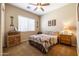 Cozy bedroom with a wooden dresser, ceiling fan, and window blinds at 13050 W Pinnacle Vista Dr, Peoria, AZ 85383