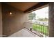 Cozy balcony includes an iron railing with a street view, green foliage, and an exterior wall lamp at 14250 W Wigwam Blvd # 2822, Litchfield Park, AZ 85340