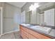 Bright bathroom featuring double sinks, wood cabinetry, and a large mirror at 14250 W Wigwam Blvd # 2822, Litchfield Park, AZ 85340
