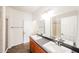 Bathroom boasts dual sinks, gray countertop, wooden cabinetry, large mirror, and a glass shower at 14250 W Wigwam Blvd # 2822, Litchfield Park, AZ 85340