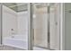 Clean bathroom with a white tiled shower-tub and a sliding glass door at 14250 W Wigwam Blvd # 2822, Litchfield Park, AZ 85340