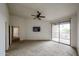 Spacious carpeted bedroom with ceiling fan, television, and balcony access at 14250 W Wigwam Blvd # 2822, Litchfield Park, AZ 85340