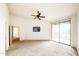 Spacious bedroom features a ceiling fan, sliding glass door, neutral carpeting, and a television at 14250 W Wigwam Blvd # 2822, Litchfield Park, AZ 85340