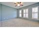 Bedroom with neutral carpet, blue walls, and large windows with white shutters at 14250 W Wigwam Blvd # 2822, Litchfield Park, AZ 85340