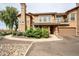 Inviting two-story home with desert landscaping, a chimney, a balcony, and a two-car garage at 14250 W Wigwam Blvd # 2822, Litchfield Park, AZ 85340