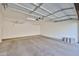 Spacious garage with overhead storage racks and concrete floor, offering ample space for vehicles and storage at 14250 W Wigwam Blvd # 2822, Litchfield Park, AZ 85340