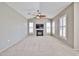 Spacious living room with a fireplace, TV, ceiling fan, and plantation shutters on multiple windows at 14250 W Wigwam Blvd # 2822, Litchfield Park, AZ 85340
