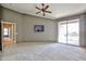Expansive main bedroom featuring a ceiling fan, TV, and balcony access at 14250 W Wigwam Blvd # 2822, Litchfield Park, AZ 85340