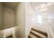 Carpeted stairs leading down to a white door and tile flooring, with an archway in the background at 14250 W Wigwam Blvd # 2822, Litchfield Park, AZ 85340