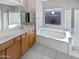 Clean bathroom with double vanity, soaking tub, and shower at 16187 W Port Royale Ln, Surprise, AZ 85379