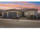 Two-car garage, light colored stucco, and desert landscaping at 17899 W Mountain Sky Ave, Goodyear, AZ 85338