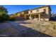 Spacious backyard featuring gravel, a covered patio, and a low brick fence at 17965 W Carol Ave, Waddell, AZ 85355