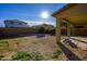 Expansive backyard with green grass, a gravel area, and a covered patio at 17965 W Carol Ave, Waddell, AZ 85355