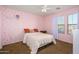 Bright bedroom with a large window, a ceiling fan, and cozy brown carpet at 17965 W Carol Ave, Waddell, AZ 85355