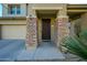Inviting front entryway with stone pillars, a secure door, and a well-lit porch at 17965 W Carol Ave, Waddell, AZ 85355