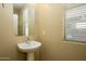 Cozy half bathroom features a pedestal sink, a window with blinds, and neutral wall paint at 17965 W Carol Ave, Waddell, AZ 85355