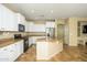 Open kitchen with white cabinets, granite countertops, and stainless-steel appliances at 17965 W Carol Ave, Waddell, AZ 85355