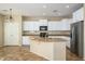 Modern kitchen features granite countertops, stainless steel appliances, and white cabinets at 17965 W Carol Ave, Waddell, AZ 85355