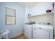 Well-organized laundry room with a window, a shelf, and a modern washer and dryer at 17965 W Carol Ave, Waddell, AZ 85355