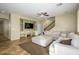 Spacious living room with custom built-ins, a ceiling fan, and a staircase at 17965 W Carol Ave, Waddell, AZ 85355