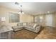Cozy living room with plush sectional couch, neutral decor, and lots of natural light at 17965 W Carol Ave, Waddell, AZ 85355