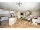 Bright, open living space featuring a kitchen island, large sofa, and tiled floors at 17965 W Carol Ave, Waddell, AZ 85355