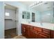 A double vanity and cherry wood cabinets complement the ensuite main bathroom at 17965 W Carol Ave, Waddell, AZ 85355
