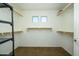 A spacious walk-in closet offers built-in shelving, ample lighting, and lots of storage at 17965 W Carol Ave, Waddell, AZ 85355