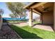 Spacious backyard featuring artificial turf, a covered patio, and a large mural on the fence at 18716 N Jameson Dr, Maricopa, AZ 85138