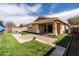 Well-maintained backyard with an outdoor covered patio, beautiful lawn, and hardscaped landscape at 18716 N Jameson Dr, Maricopa, AZ 85138