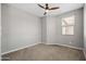 A carpeted bedroom with a ceiling fan and a window with blinds provides a bright and airy feel at 18716 N Jameson Dr, Maricopa, AZ 85138