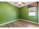 Empty bedroom showcasing green walls, hardwood floors, and a window at 18716 N Jameson Dr, Maricopa, AZ 85138