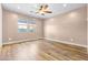 Spacious bedroom featuring wood floors, a ceiling fan, and natural light at 18716 N Jameson Dr, Maricopa, AZ 85138