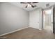 Bedroom boasts neutral paint, carpeting, closet, ceiling fan, and a doorway at 18716 N Jameson Dr, Maricopa, AZ 85138