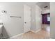Hallway leading into a bathroom, featuring a towel rack and door at 18716 N Jameson Dr, Maricopa, AZ 85138