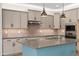 Well-lit kitchen with gray cabinets, stainless steel appliances, and large island with sink at 18716 N Jameson Dr, Maricopa, AZ 85138