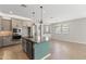 Open concept kitchen with stainless appliances, light gray cabinets and eat-in island at 18716 N Jameson Dr, Maricopa, AZ 85138