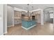 A modern kitchen with grey cabinets, a turquoise island, and pendant lights is perfect for entertaining at 18716 N Jameson Dr, Maricopa, AZ 85138