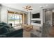 This staged living room has a modern fireplace, comfortable seating, and sliding glass doors to the patio at 18716 N Jameson Dr, Maricopa, AZ 85138