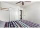 Bedroom with wood-look floors, ceiling fan, and built-in shelving at 18907 N Vemto St, Maricopa, AZ 85138