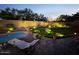 Backyard garden with pool, lush green grass and landscape lighting at 2073 E Wildhorse Dr, Chandler, AZ 85286