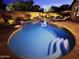 Backyard pool with stairs on brick patio surrounded by lush green trees and landscape lighting at 2073 E Wildhorse Dr, Chandler, AZ 85286