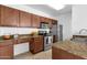 Well-lit kitchen with stainless steel appliances, granite countertops and wood cabinetry at 2134 E Broadway Rd # 2033, Tempe, AZ 85282