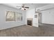 Bright living room with a cozy fireplace, ceiling fan, and natural light streaming through the window at 2134 E Broadway Rd # 2033, Tempe, AZ 85282