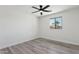 A minimalist bedroom design featuring a gray ceiling fan, wood floors, and white walls at 2217 N 79Th St, Scottsdale, AZ 85257
